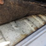 Under the driver's seat carpet, no rust, good condition, no dents in the carpet.